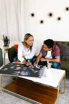 A mother and son working together on a solar system school project in their living room.