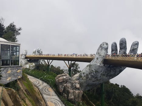 Golden Bridge held by giant hands in Ba Na Hills, Vietnam, attracts tourists.