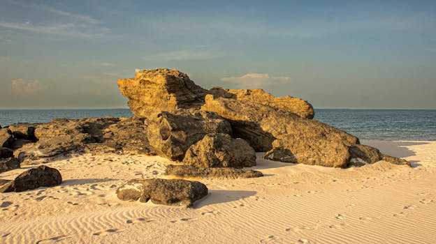 Scenic view of golden rock formations on Ponta de Pedras beach with ocean horizon.