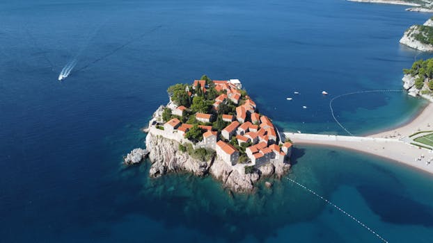 A breathtaking aerial view of the picturesque Sveti Stefan Island, Montenegro, surrounded by azure waters.