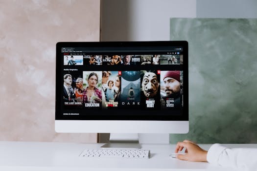A modern workspace featuring a desktop screen displaying popular streaming series on Netflix.